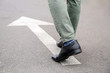 © Pixel-Shot - Young man going along road with arrow marking. Concept of choice