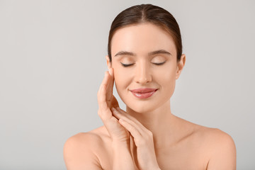 Poster - Beautiful young woman with healthy skin on light background