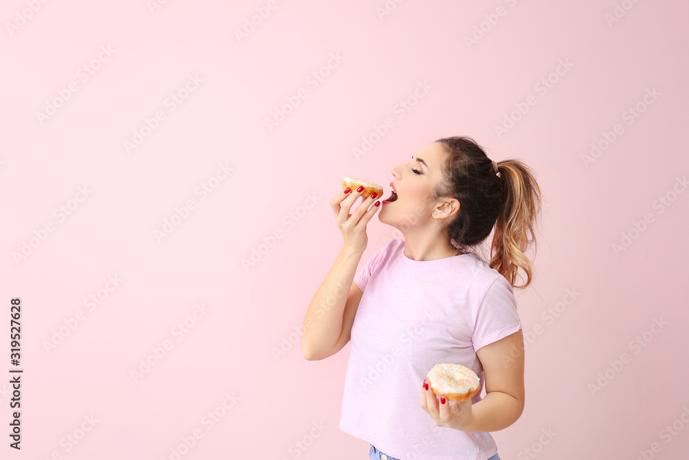 Beautiful young woman with donuts on color background - obrazy, fototapety, plakaty 