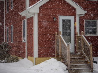 Wall Mural - red suburban house in the snow storm