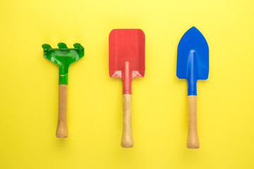 Home gardening abstract made of shovels and rake isolated on yellow.