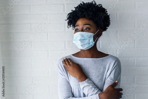 Cuadros en Lienzo Portrait of young African-American woman wearing disposable medical face mask