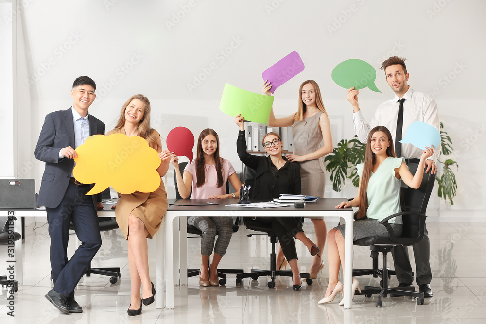 Group of business people with blank speech bubbles in office