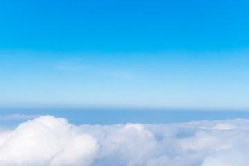 Wall Mural - airplane window view above beautiful white cloud summer blue sky and sun light abstract nature.