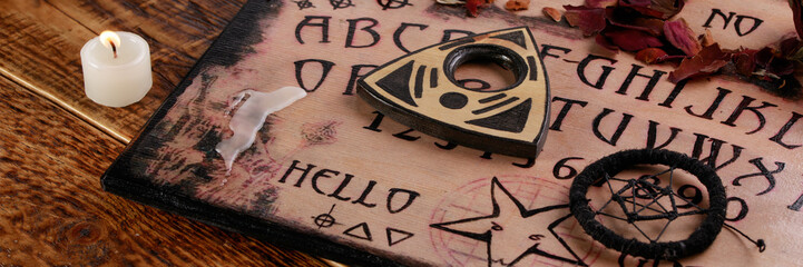 Wall Mural - Spiritual board ouija with candles close-up. Mystical ritual of calling dead spirits. Macro.