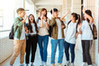 © Tom Wang - Group of happy students walking along the corridor at college