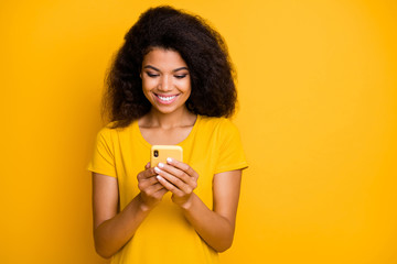 Close-up portrait of her she nice attractive lovely cheerful cheery wavy-haired girl using cell browsing web service online internet isolated over bright vivid shine vibrant yellow color background