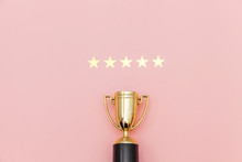 Simply Flat Lay Design Winner Or Champion Gold Trophy Cup And 5 Stars Rating Isolated On Pink Pastel Background. Victory First Place Of Competition. Winning Or Success Concept. Top View Copy Space.