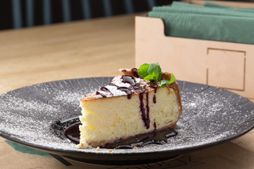 Wall Mural - Tasty homemade cheesecake. Cheesecake with caramel cream on white plate on wooden table.