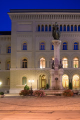 Wall Mural - Fountain on street in old city center of Bern, Switzerland. Illuminated late in the evening