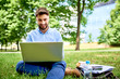 © baranq - Picture of smiling young businessman working on laptop while having luch break in the park