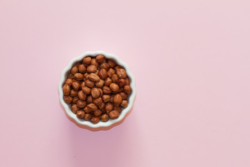 hazelnuts and walnuts in two white cups on a pink background. lots of nuts. the concept of proper nutrition and health. Healthy food and snacks, organic vegetarian food. the view from the top.