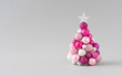 © Zamurovic Brothers - Christmas tree with pink bauble decoration. Minimal Holiday composition. Creative Christmas background.