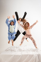 Children In Soft Warm Pajamas Colored Bright Playing At Home. Little Girls Having Fun, Party, Laughting, Jumping Together, Look Stylish And Happy. Concept Of Childhood, Leisure Activity, Happiness.