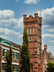 Wall Mural - An old classic brick church tower on a blue background