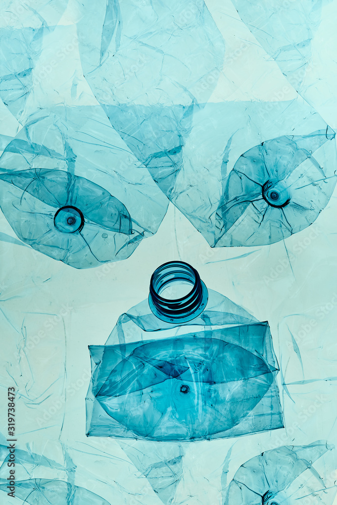Squashed Plastic Empty plastic squashed bottles over blue background. Collecting plastic ...