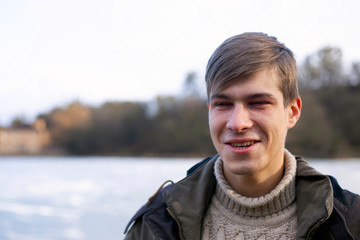 Wall Mural - portrait of a young guy. man in outdoor nature on the background of a frozen lake