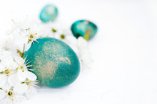Easter Background.  Turquoise Easter Eggs And White Spring Flowers On A White Background Close-up, Soft Focus