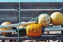 Yellow Buoys On Bench At Beach