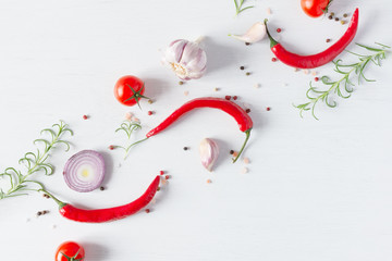 Wall Mural - Composition of colorful pepper seeds, fresh chili pepper, tomatoes, garlic, blue onion and rosemary herb top view on white wooden background.