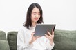 © garage38 - リビングでタブレットを操作する女性