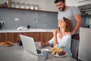 Wall Mural - Girlfriend in the kitchen with her boyfriend enjoying in nice morning.