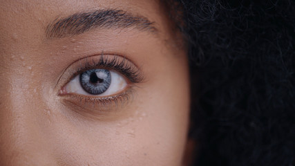 Close-up of beautiful african young woman face with cool digital eye with micro chips inside. Macro view.