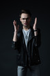 © LIGHTFIELD STUDIOS - worried stylish brutal man in biker jacket gesturing isolated on black