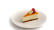 Exotic cheese cake with crunchy base, exotic orange glaze and some white chocolate and raspberry on it, on a beige plate, white background