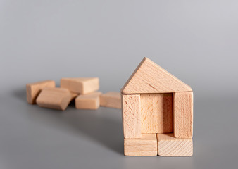 House built of wooden blocks. The development of children's motor skills. Construction concept. Mortgages and real estate investments.