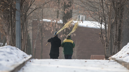 two janitor with a broom in the park