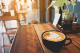 Latte cup on wooden table blur coffee shop background
