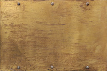 Rusty Golden Metal Plate With Yellow And Orange Tones - Worn Steampunk Background With Screws And Scratches	