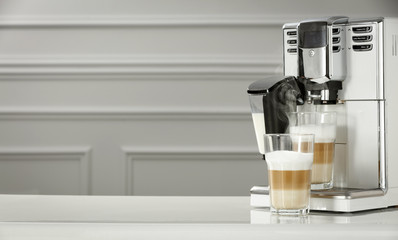 Poster - Fresh hot caffe latte and white coffee machine in home interior. 