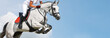 Girl jumping with white horse, isolated, blue sky, white clouds background. Rider in white uniform, equestrian sports. Horizontal header or banner. Ambition, breaking through, free, health concept.