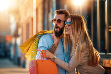 Happy couple enjoying after shopping in the city