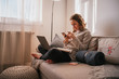 © Irving Sandoval - Home office. Young business woman working at home with her computer and using her cell phone, sitting in an armchair during sunset