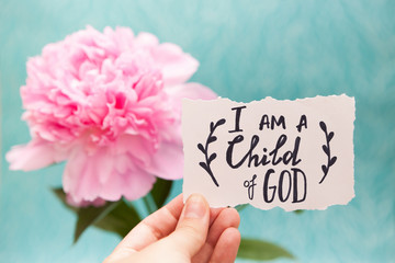 i am a child of god - christian calligraphy lettering on card with pink peony flower, biblical verce