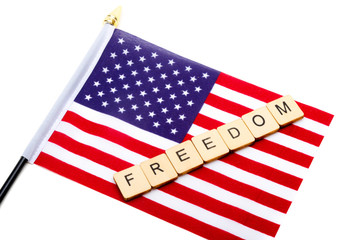 The flag of the United States isolated on a white background with a sign reading Freedom