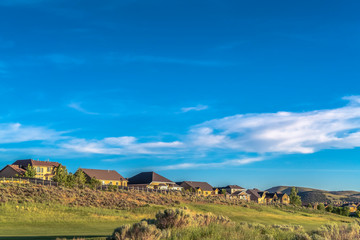 Wall Mural - Scenic landscape of houses on a hill under vibrant blue sky on a sunny day