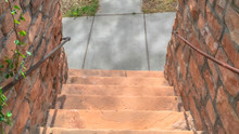 Panorama Outdoor Stairs Between Retaining Walls Made Of Stone Leading To A Sunlit Road