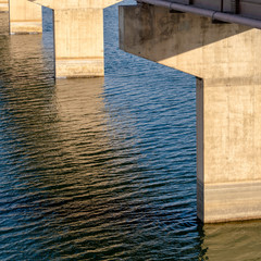 Canvas Print - Square Deck of a beam bridge supported by abutments or piers spanning over blue water