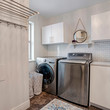 Square Laundry room interior with cabinets wahing machine and dryer against white wall