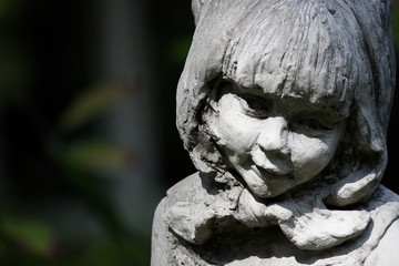  Cloes up photo of arden stone sculpture of a childern. Children statue.
