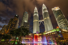 Low Angle View Of Illuminated Petronas Towers Amidst Buildings At Night