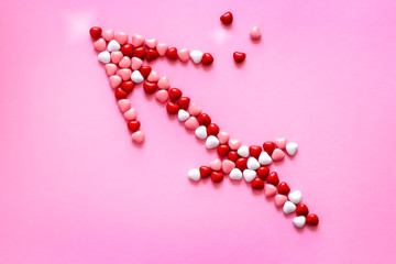 Wall Mural - Cupid arrow symbol of lovers Multicolored candy or Pills shape of hearts. Concept Valentine's Day.