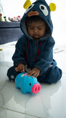 Cute  little asian  baby boy with piggy bank