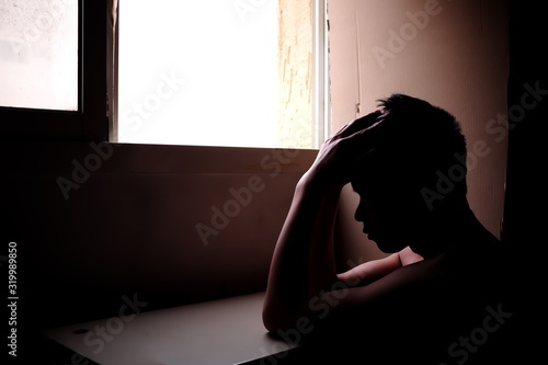 Silhouette of a sad and problematic shirtless young man next to a window light. Stress, depression, infertility, marriage problem and mental health issue