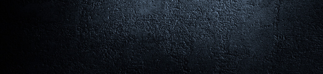 Black grunge background. Bright web banner. Reflection of light on a rough concrete wall. Copy space for your design. Website header.