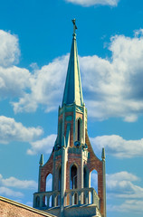 Wall Mural - An old church steeple with bell tower against a blue sky